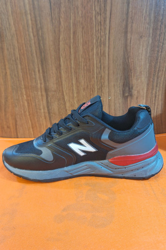 کتانی رانینگ (Running) مردانه طرح نیوبالانس (New Balance) مشکی با لوگوی N سفید و زیره آجدار خاکستری/قرمز، کفش اسپرت روزمره شیک
