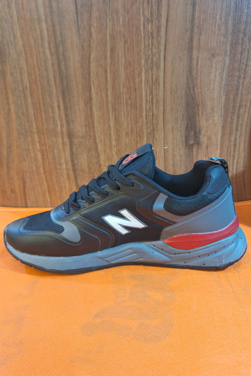 کتانی رانینگ (Running) مردانه طرح نیوبالانس (New Balance) مشکی با لوگوی N سفید و زیره آجدار خاکستری/قرمز، کفش اسپرت روزمره شیک
